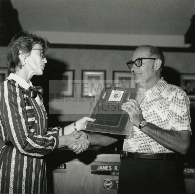 Woman awards plaque to Vern Smith