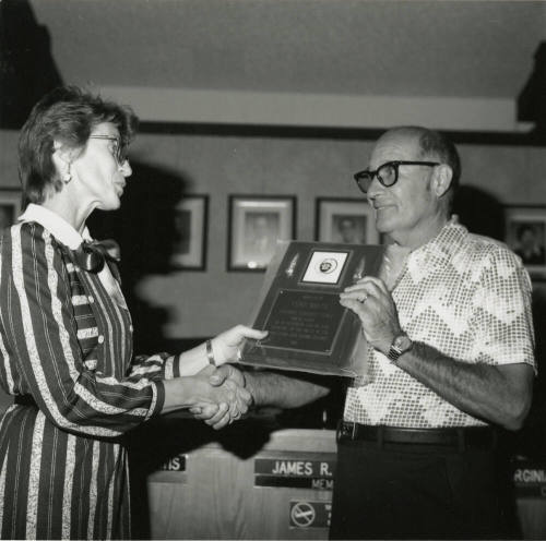 Woman awards plaque to Vern Smith