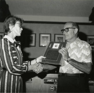 Woman awards plaque to Vern Smith
