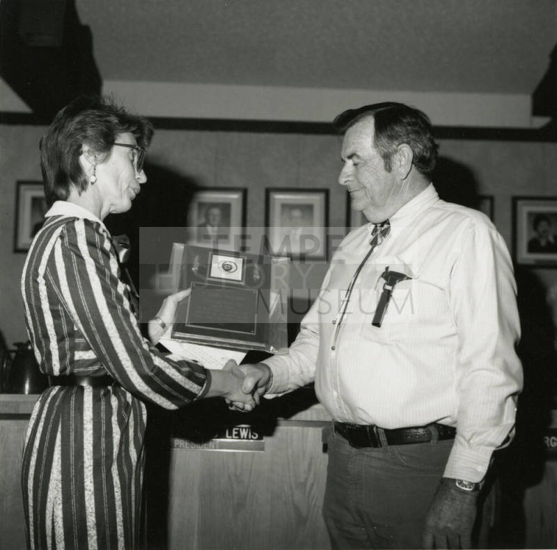 Woman awards plaque to Vern Smith