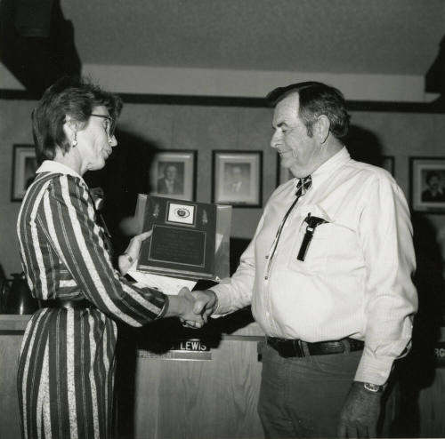 Woman awards plaque to Vern Smith