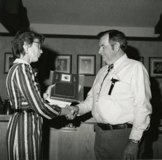 Woman awards plaque to Vern Smith