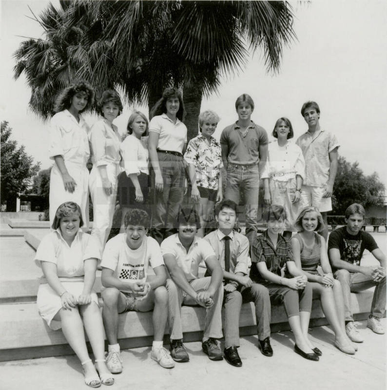 Group of youths posing outside in front of a palm tree