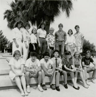 Group of youths posing outside in front of a palm tree