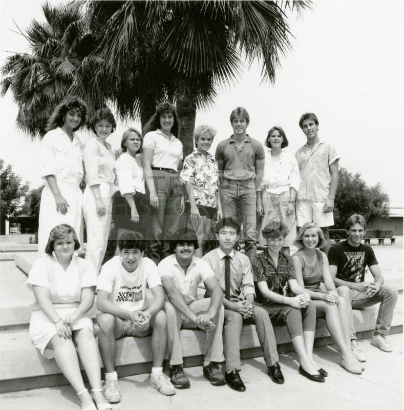 Group of youths posing outside in front of a palm tree