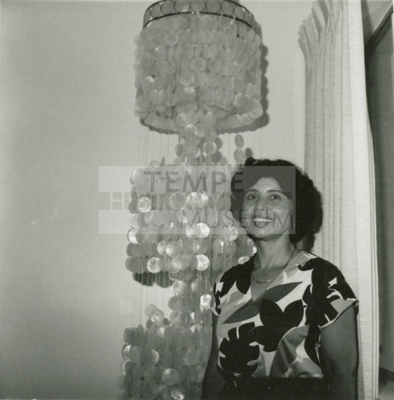 Unidentified Lady and Ornate 3-Tiered Hanging Lamp