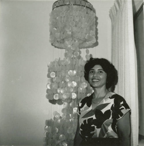Unidentified Lady and Ornate 3-Tiered Hanging Lamp