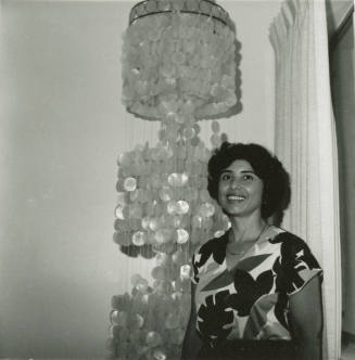 Unidentified Lady and Ornate 3-Tiered Hanging Lamp