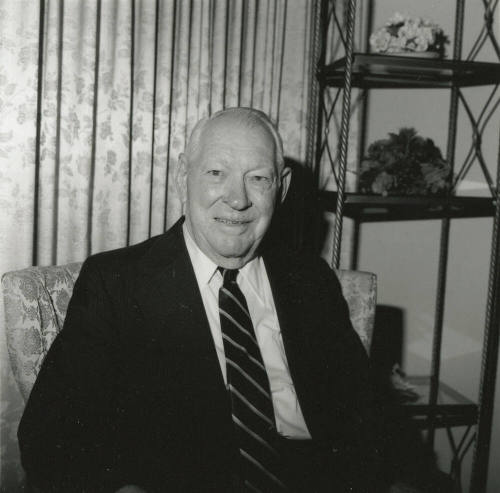 Unidentified Smiling Man Sits & Smiles in Living Room - (1 of 2)