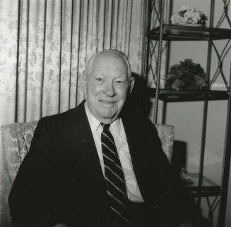 Unidentified Smiling Man Sits & Smiles in Living Room - (1 of 2)