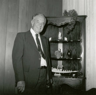 Unidentified Man In Front of Figurine Display Case