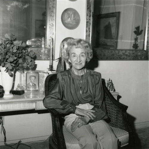 Elderly woman sits inside her home