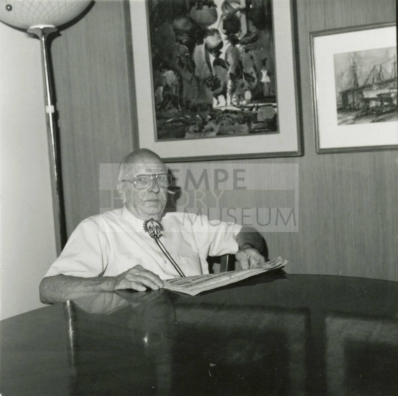 Elderly man with newspaper at dining table
