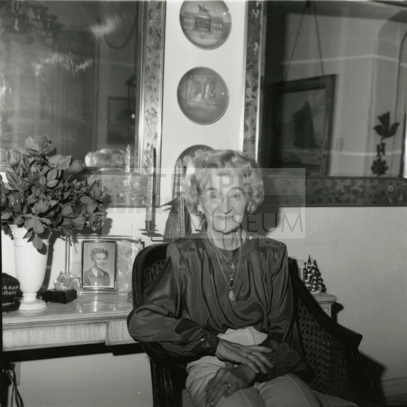 Elderly woman sits inside her home