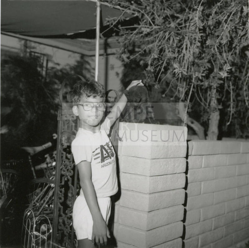 Unidentified Boy Pets Unidentified Black Cat