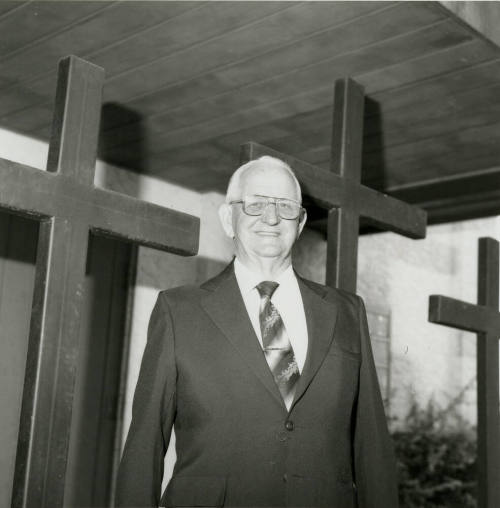 Unidentified Man Stands In Front of 3 Crosses