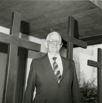 Unidentified Man Stands In Front of 3 Crosses
