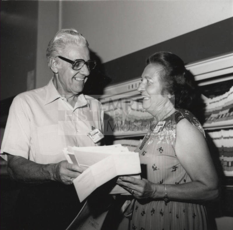 Unidentified Man & Woman Examine Papers