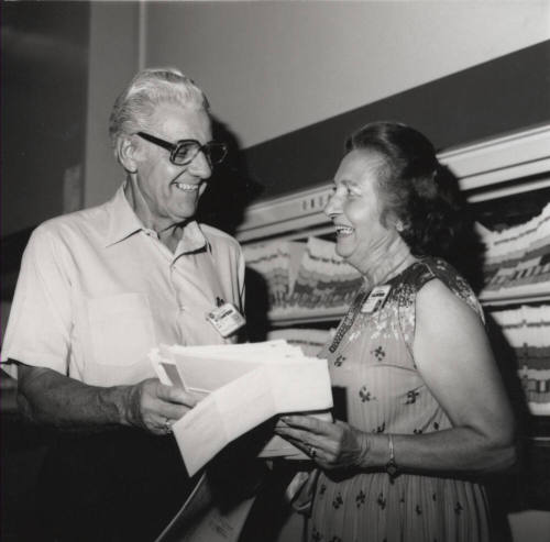 Unidentified Man & Woman Examine Papers