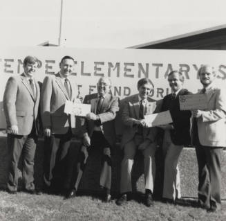 Group of men in front of a Tempe Elementary School sign