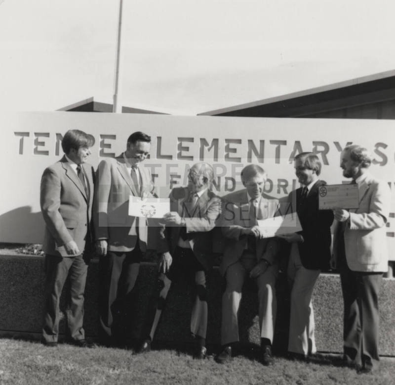 Group of men in front of a Tempe Elementary School sign