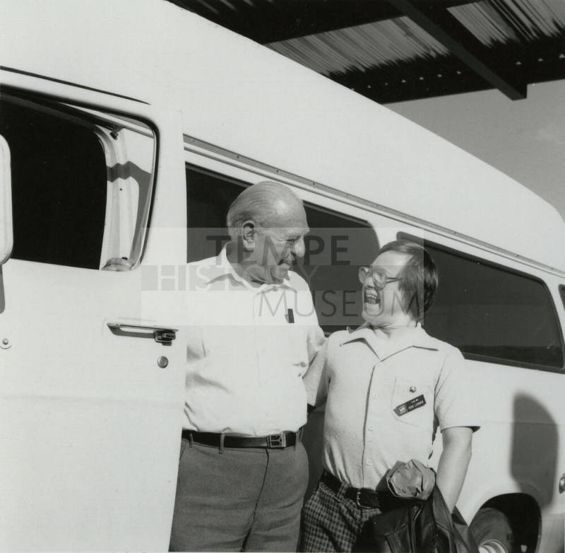 Men standing next to a van. - December 1985