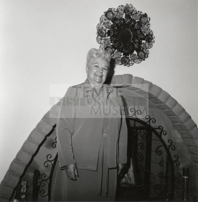 Unidentified Woman standing in front of Fireplace