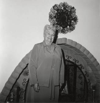 Unidentified Woman standing in front of Fireplace