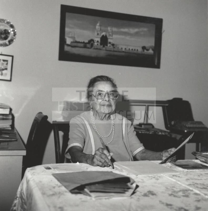 Unidentified Woman sitting at Table and working with Papers