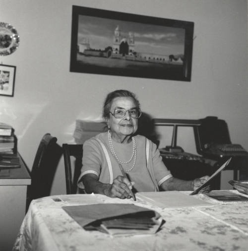 Unidentified Woman sitting at Table and working with Papers