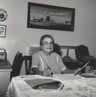 Unidentified Woman sitting at Table and working with Papers