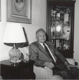 Unidentified Man seated in living room chair - (1 of 2)