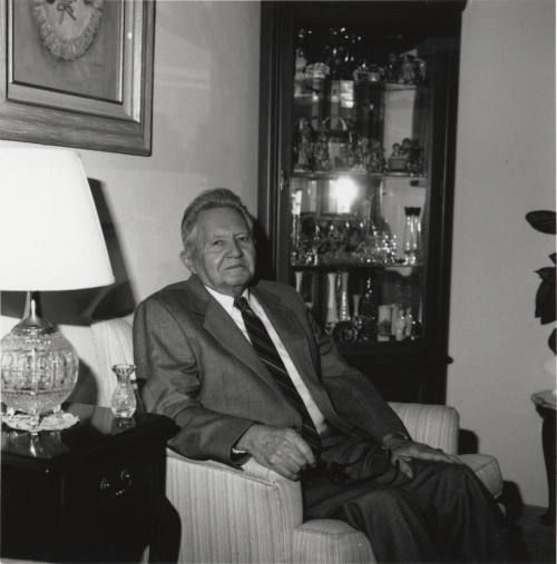Unidentified Man seated in living room chair - (2 of 2)