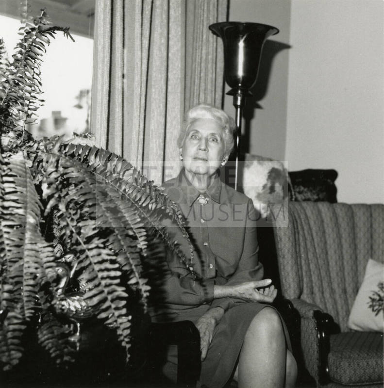 Unknown lady seated by a fern