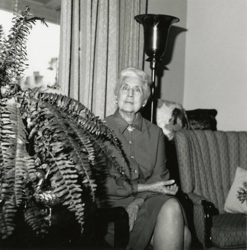 Unknown lady seated by a fern