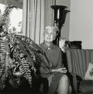 Unknown lady seated by a fern