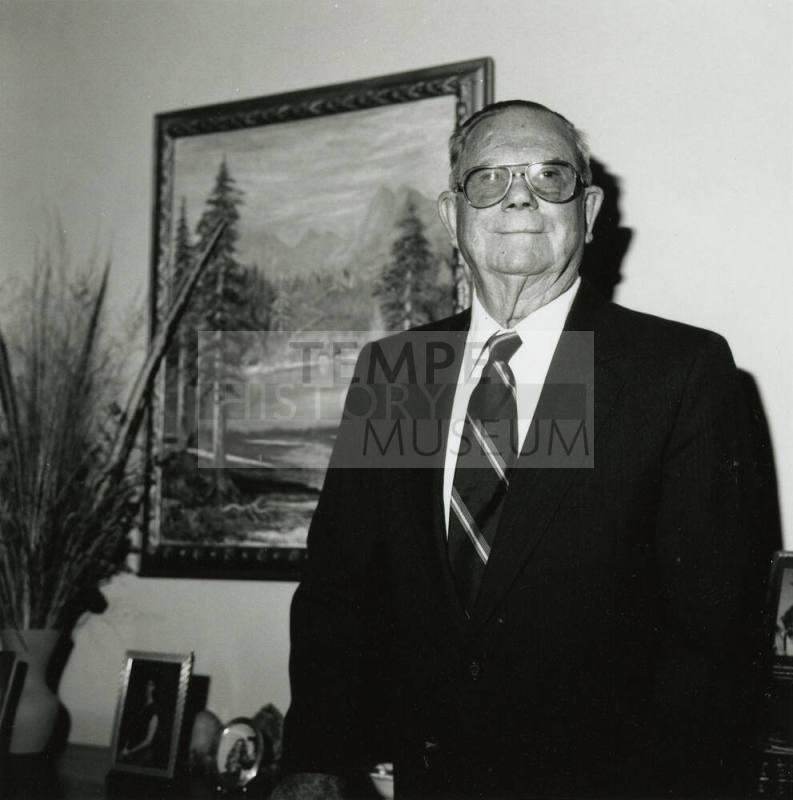 Uknown Man Standing in Front of Landscape Painting