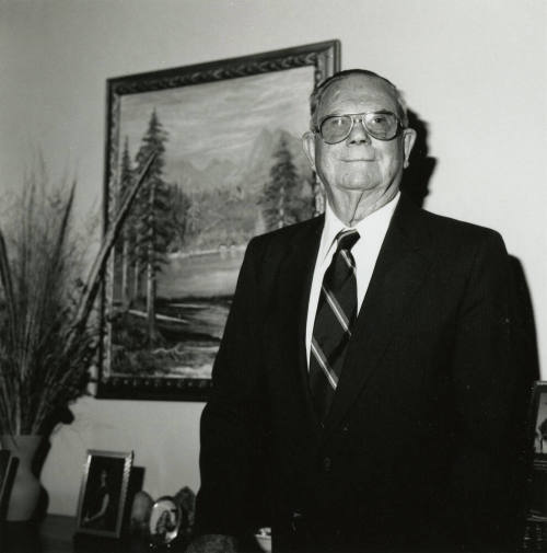 Uknown Man Standing in Front of Landscape Painting