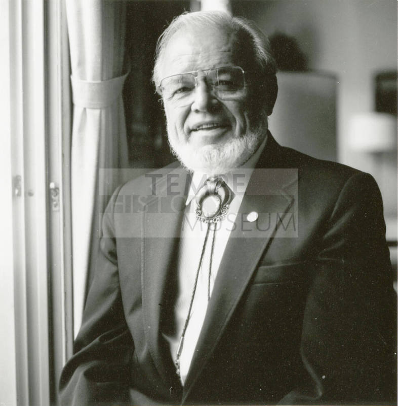 A portrait of an unknown man standing next to a window