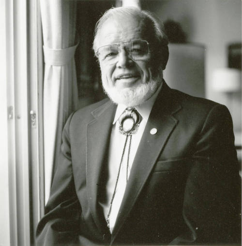 A portrait of an unknown man standing next to a window
