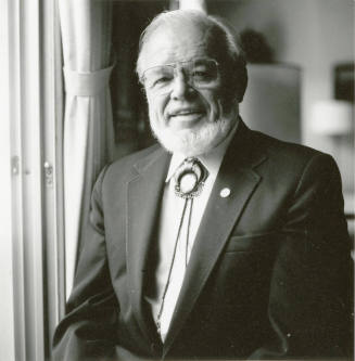 A portrait of an unknown man standing next to a window