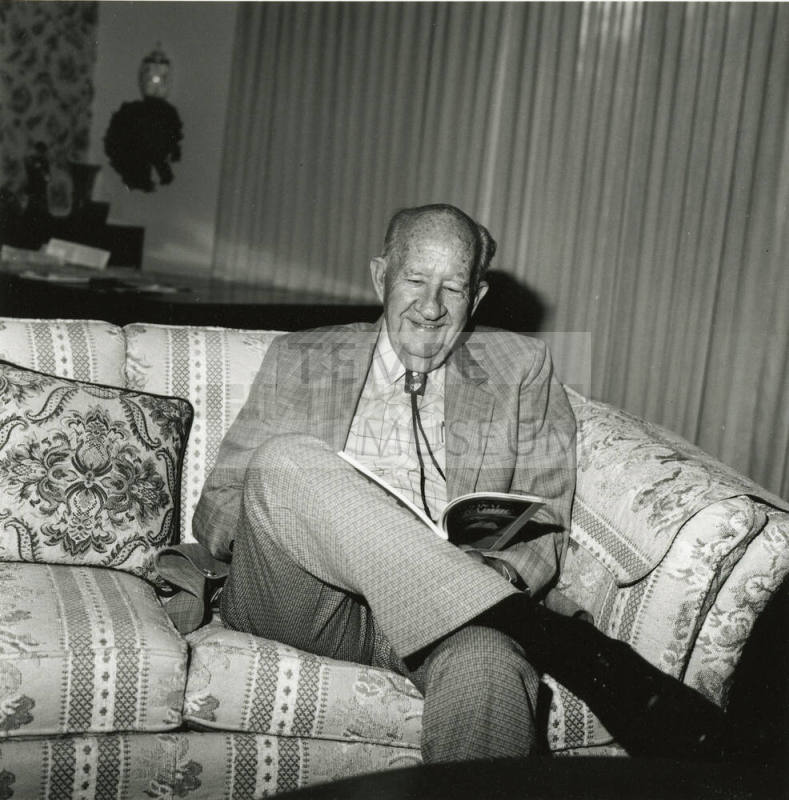Older man sits on sofa in living room