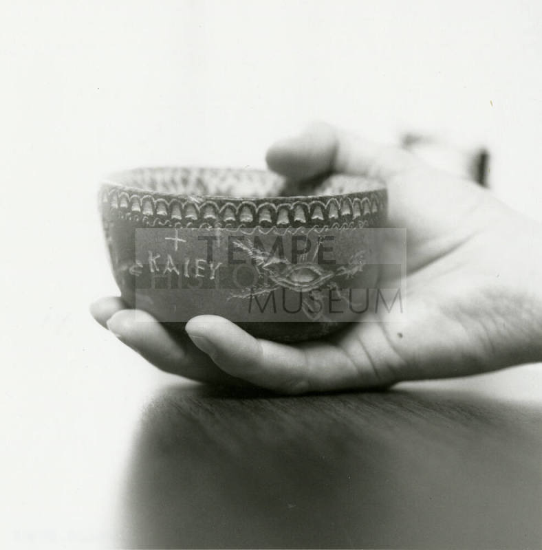 Hand holds small ceramic bowl reading "KAlEY"