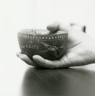 Hand holds small ceramic bowl reading "KAlEY"