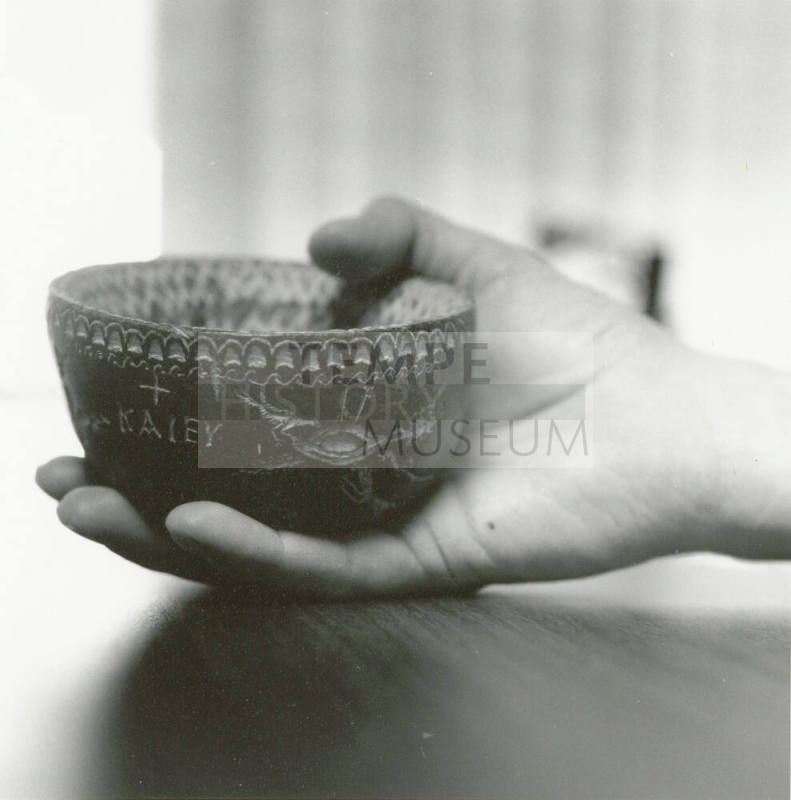 Hand holds small ceramic bowl reading "KAlEY"