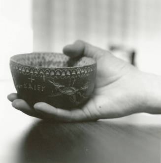 Hand holds small ceramic bowl reading "KAlEY"