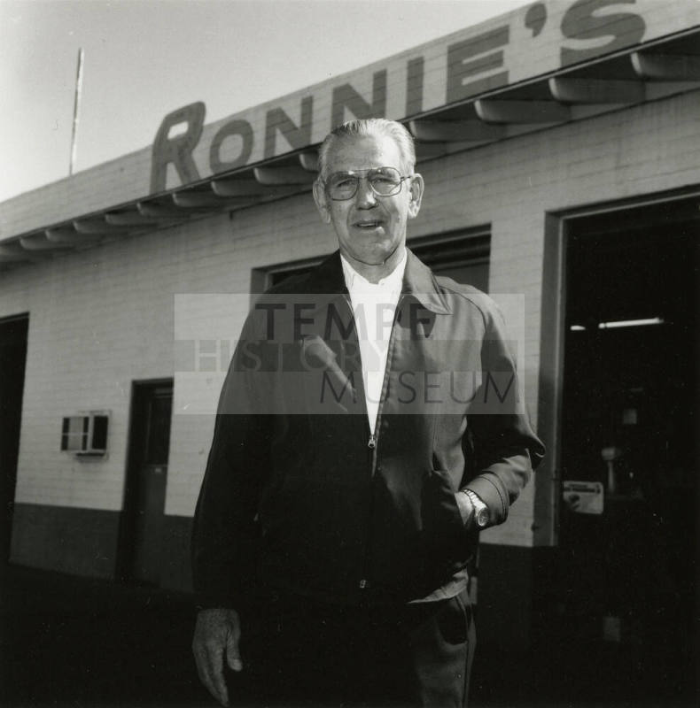 Man stands outside shop labeled "Ronnie's"