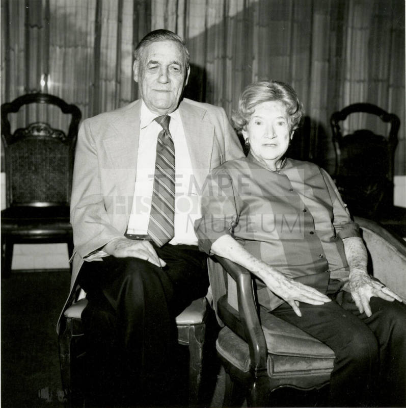 Seated older couple surrounded by chairs