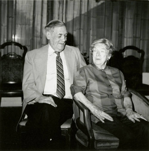 Seated older couple surrounded by chairs