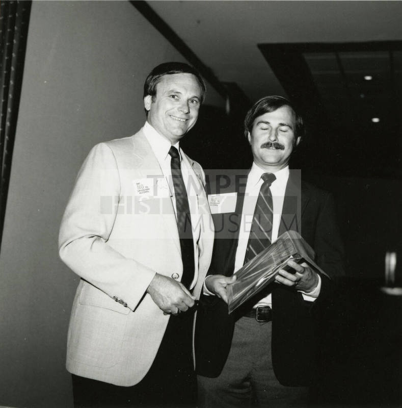 Harry Mitchell presents an award to an unknown man